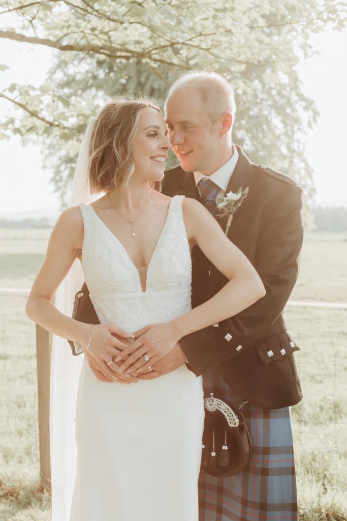 Bride & Groom cuddling at Shieldhill Castle Hotel in Biggar